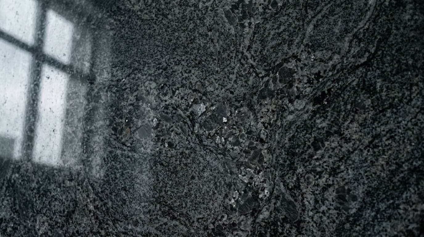 Close-up of black granite tile with polished finish and natural patterns.