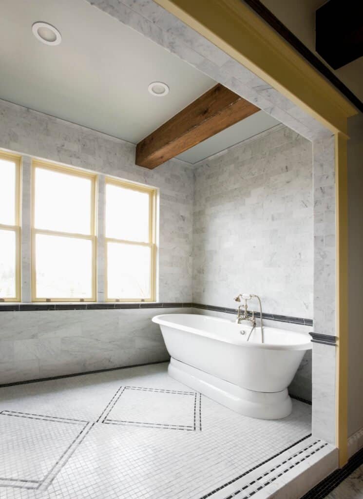 Elegant bathroom with freestanding bathtub and large window.