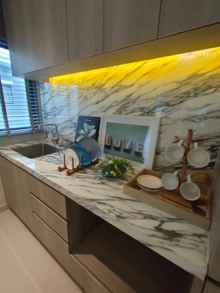 Elegant marble kitchen countertop with decorative items and warm lighting.
